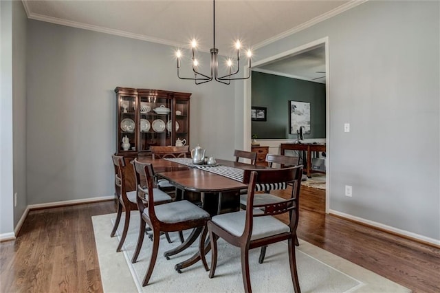 14169 W 115th Ter, Olathe, KS 66062 - dining area featuring wood finished floors, a chandelier, and ornamental molding