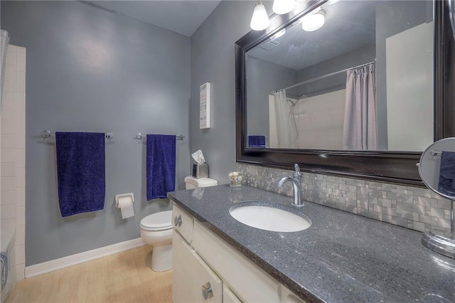 6520 W 51st St, Mission, KS 66202 - full bathroom with tasteful backsplash, vanity, toilet, wood finished floors, and a shower with curtain