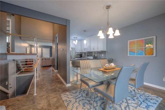 6520 W 51st St, Mission, KS 66202 - dining room with a chandelier, baseboards, and concrete floors