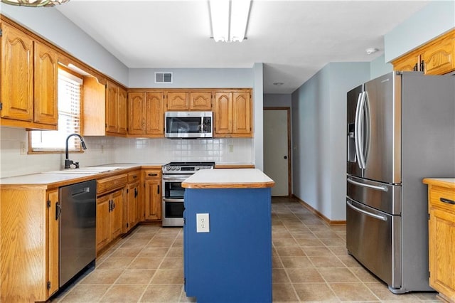 11207 W 109th St, Overland Park, KS 66210 - kitchen with stainless steel appliances, a sink, tasteful backsplash, light countertops, and a center island