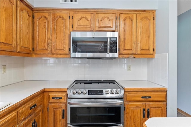 11207 W 109th St, Overland Park, KS 66210 - kitchen featuring appliances with stainless steel finishes, brown cabinets, and light countertops