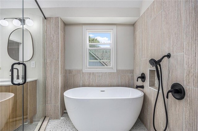 1345 NE Foxwood Dr, Lees Summit, MO 64086 - bathroom featuring tile walls, a soaking tub, vanity, wainscoting, and speckled floor