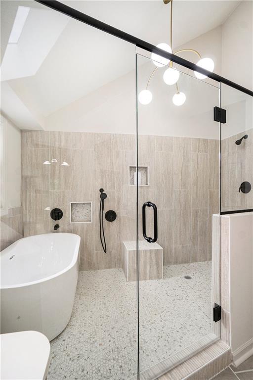 1345 NE Foxwood Dr, Lees Summit, MO 64086 - bathroom featuring a soaking tub, vaulted ceiling, a shower stall, and toilet