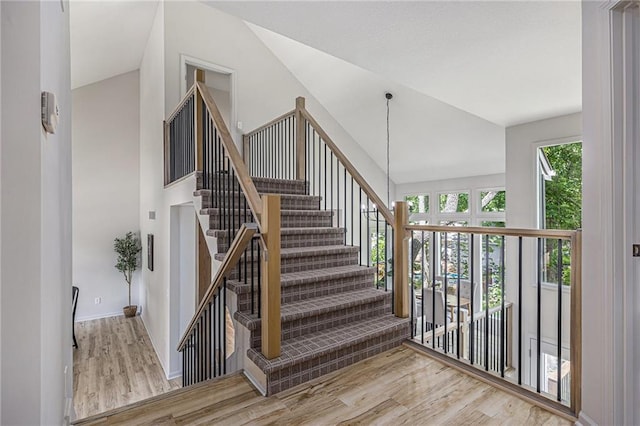 1345 NE Foxwood Dr, Lees Summit, MO 64086 - stairs featuring wood finished floors, high vaulted ceiling, and baseboards