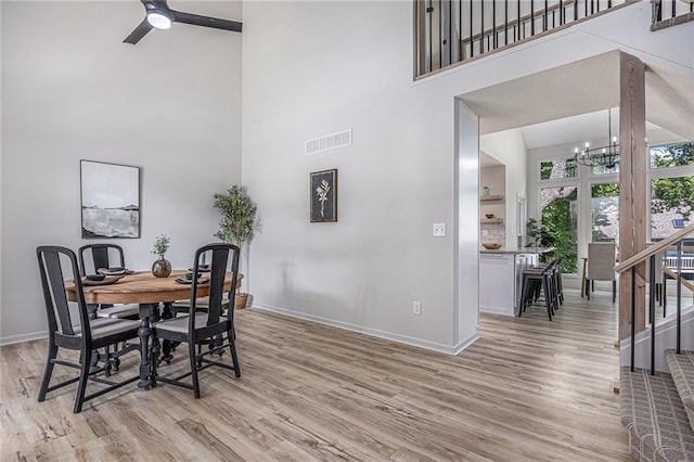 1345 NE Foxwood Dr, Lees Summit, MO 64086 - dining room with a high ceiling, a chandelier, baseboards, light wood-style flooring, and a ceiling fan