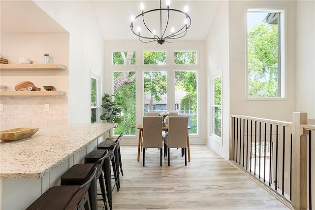 1345 NE Foxwood Dr, Lees Summit, MO 64086 - dining area featuring healthy amount of natural light, a chandelier, light wood-style flooring, and high vaulted ceiling