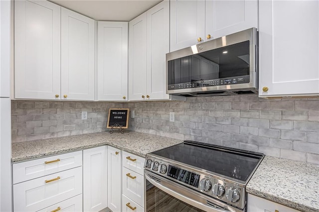 1345 NE Foxwood Dr, Lees Summit, MO 64086 - kitchen featuring stainless steel appliances, white cabinets, tasteful backsplash, and light stone counters