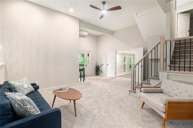 1345 NE Foxwood Dr, Lees Summit, MO 64086 - living room featuring carpet floors, a ceiling fan, stairs, a towering ceiling, and baseboards