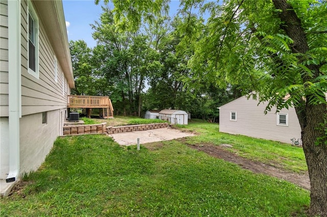 6201 N Topping Ave, Kansas City, MO 64119 - view of grassy yard with a wooden deck, central AC unit, and view of scattered trees
