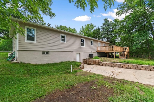 6201 N Topping Ave, Kansas City, MO 64119 - back of property with a wooden deck, a lawn, an attached garage, cooling unit, and stairs