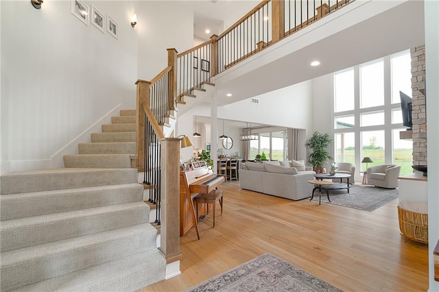 1120 Hillswick Ln, Raymore, MO 64083 - stairs with a towering ceiling and wood finished floors