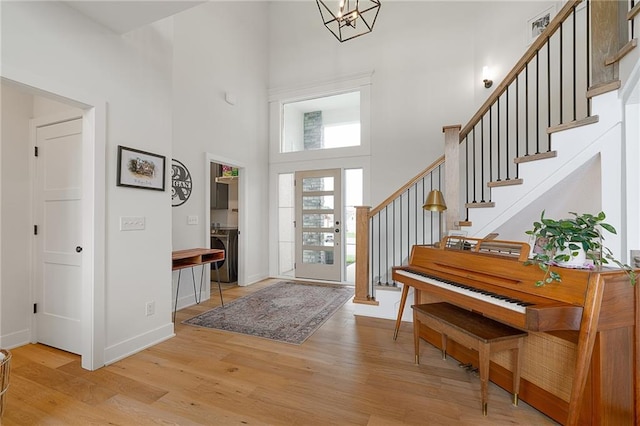 1120 Hillswick Ln, Raymore, MO 64083 - foyer featuring a towering ceiling, light wood-style floors, stairway, baseboards, and a chandelier