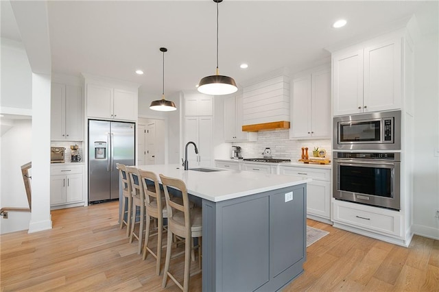 1120 Hillswick Ln, Raymore, MO 64083 - kitchen featuring stainless steel appliances, a sink, tasteful backsplash, light wood finished floors, and recessed lighting