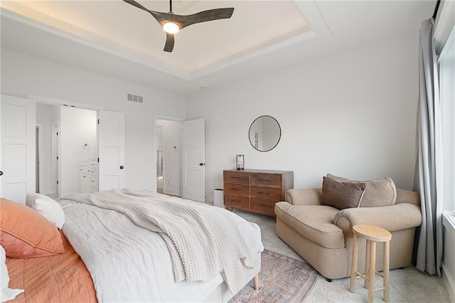 1120 Hillswick Ln, Raymore, MO 64083 - bedroom featuring a raised ceiling, light colored carpet, ensuite bathroom, and a ceiling fan