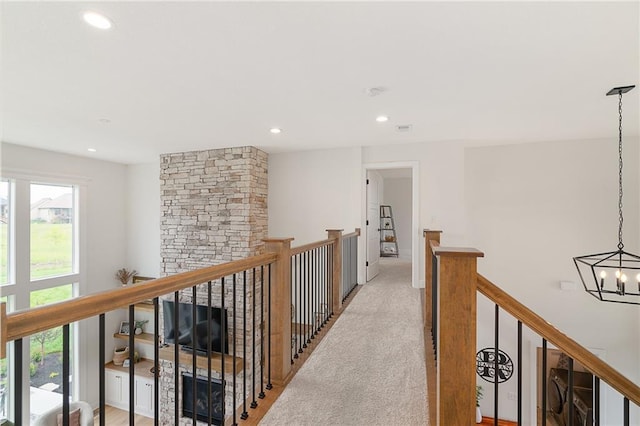 1120 Hillswick Ln, Raymore, MO 64083 - hallway with an upstairs landing, plenty of natural light, a chandelier, recessed lighting, and light colored carpet