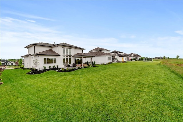 1120 Hillswick Ln, Raymore, MO 64083 - rear view of property featuring a lawn and a patio