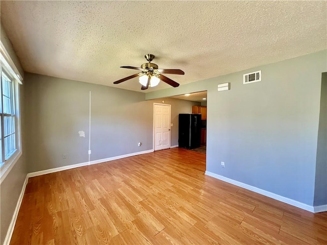 1208 E 80th St, Kansas City, MO 64131 - unfurnished room featuring light wood finished floors, ceiling fan, baseboards, and a textured ceiling