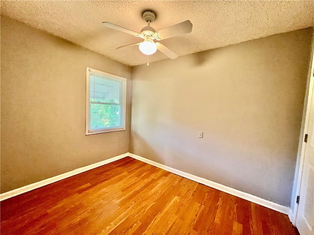 1208 E 80th St, Kansas City, MO 64131 - empty room with wood finished floors, a ceiling fan, a textured ceiling, and baseboards