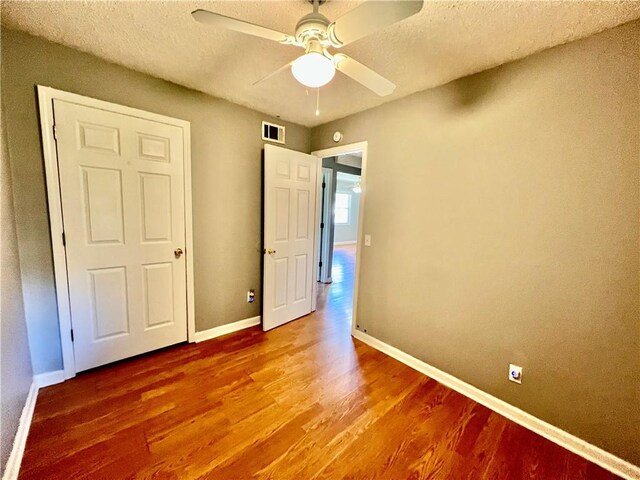 1208 E 80th St, Kansas City, MO 64131 - unfurnished bedroom featuring wood finished floors, baseboards, a ceiling fan, and a textured ceiling