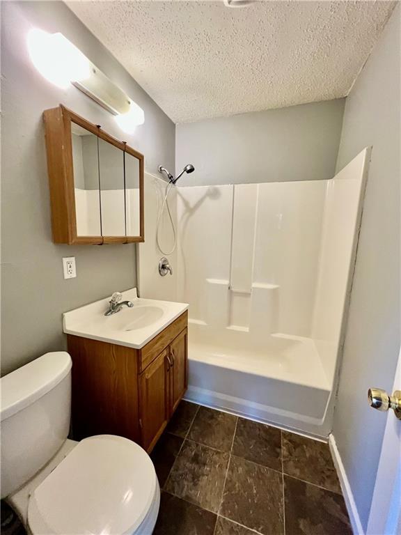 1208 E 80th St, Kansas City, MO 64131 - bathroom with toilet, a textured ceiling, vanity, and shower / bathtub combination