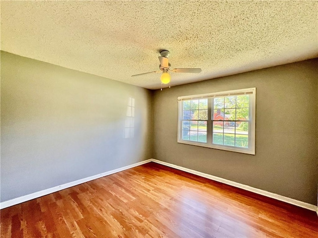 1208 E 80th St, Kansas City, MO 64131 - empty room with wood finished floors, baseboards, ceiling fan, and a textured ceiling