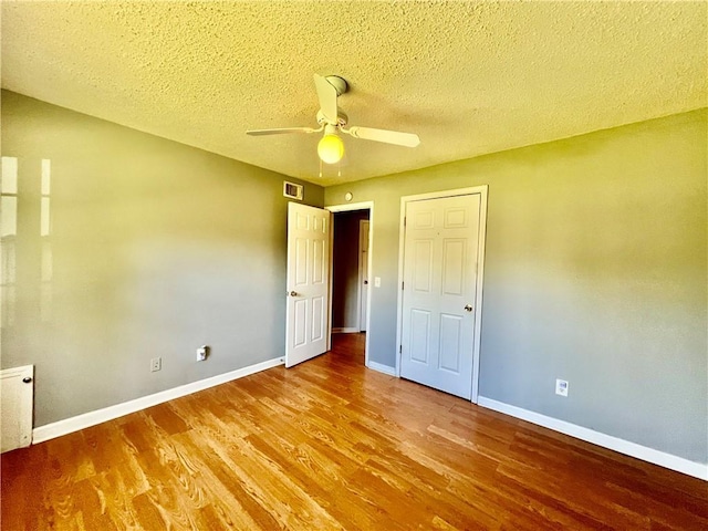 1208 E 80th St, Kansas City, MO 64131 - unfurnished bedroom with wood finished floors, baseboards, a textured ceiling, and ceiling fan