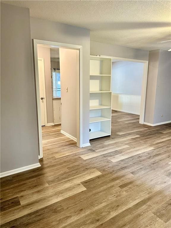 1220 N 76th Ter, Kansas City, KS 66112 - unfurnished bedroom with wood finished floors, a textured ceiling, and baseboards