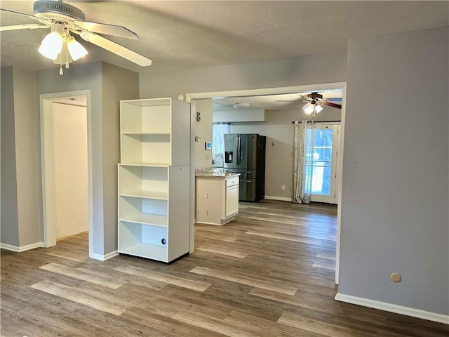 1220 N 76th Ter, Kansas City, KS 66112 - kitchen featuring black fridge with ice dispenser, ceiling fan, dark wood finished floors, baseboards, and a textured ceiling