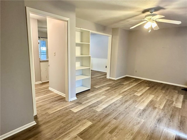 1220 N 76th Ter, Kansas City, KS 66112 - unfurnished bedroom with baseboards, wood finished floors, and ceiling fan