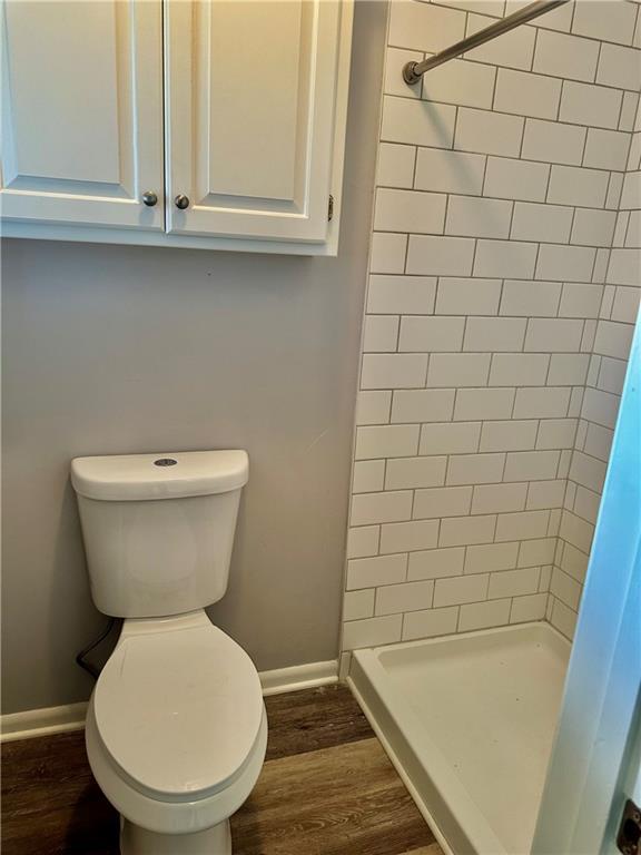 1220 N 76th Ter, Kansas City, KS 66112 - full bathroom with a shower stall, wood finished floors, toilet, and baseboards