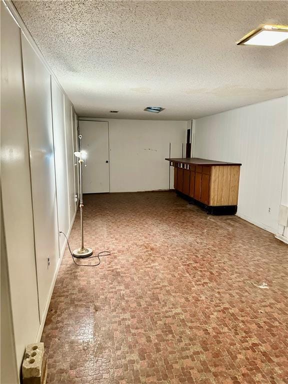 1220 N 76th Ter, Kansas City, KS 66112 - unfurnished room featuring brick patterned flooring and a textured ceiling