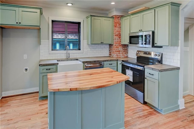 302 N Brighton Ave, Kansas City, MO 64123 - kitchen with appliances with stainless steel finishes, green cabinetry, butcher block countertops, a sink, and ornamental molding