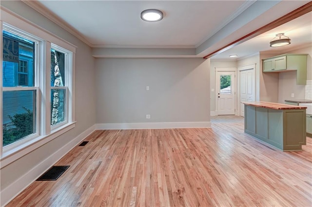 302 N Brighton Ave, Kansas City, MO 64123 - kitchen with light wood-type flooring, butcher block countertops, baseboards, crown molding, and a center island