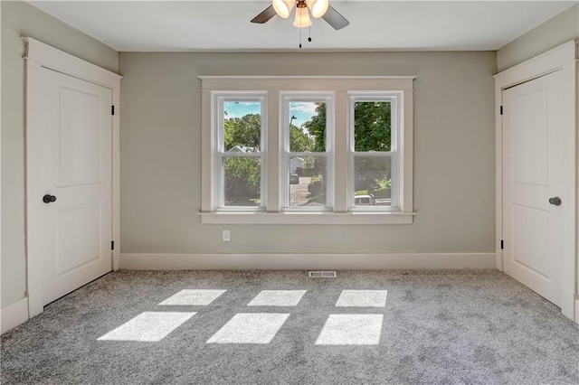 302 N Brighton Ave, Kansas City, MO 64123 - unfurnished bedroom featuring multiple windows, carpet flooring, and baseboards