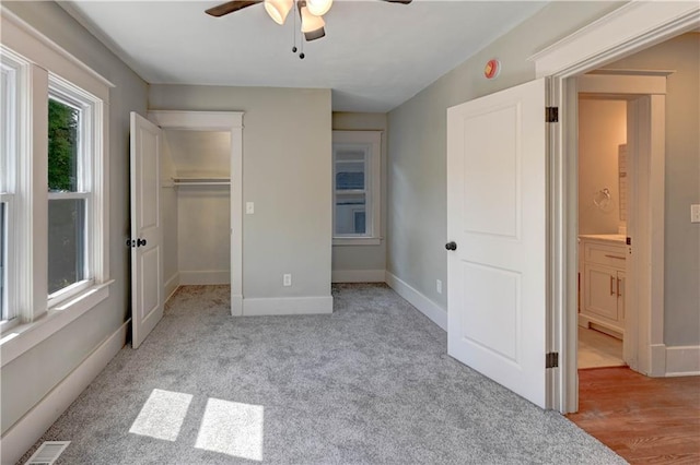 302 N Brighton Ave, Kansas City, MO 64123 - unfurnished bedroom featuring a walk in closet, baseboards, ceiling fan, and a closet