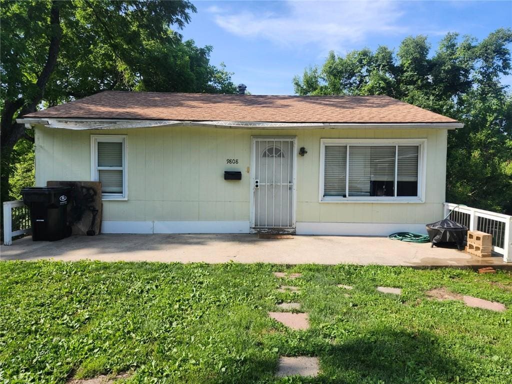 9808 E 22nd St S, Independence, MO 64052 - view of front of home with a patio, a front lawn, and roof with shingles