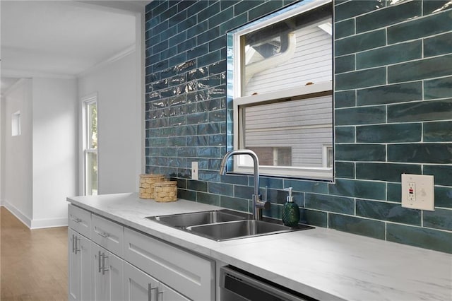 5227 Highland Ave, Kansas City, MO 64110 - kitchen featuring a sink, ornamental molding, baseboards, wood finished floors, and white cabinets