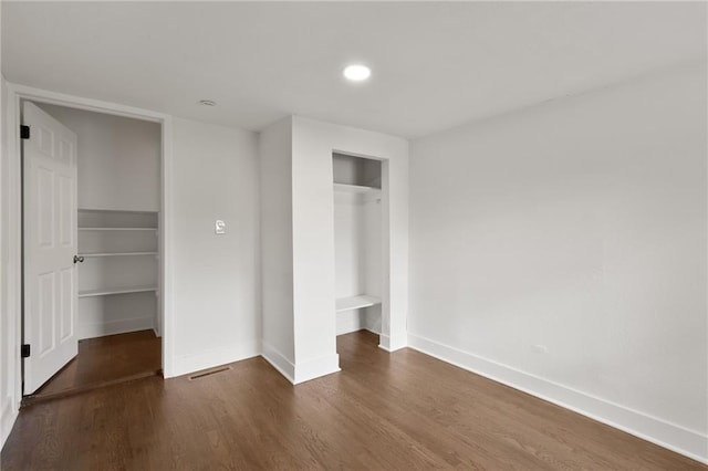 5227 Highland Ave, Kansas City, MO 64110 - unfurnished bedroom with baseboards, a closet, wood finished floors, and recessed lighting