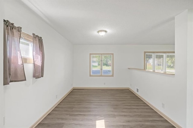10720 Sycamore Ter, Kansas City, MO 64134 - spare room featuring a textured ceiling, wood finished floors, and baseboards