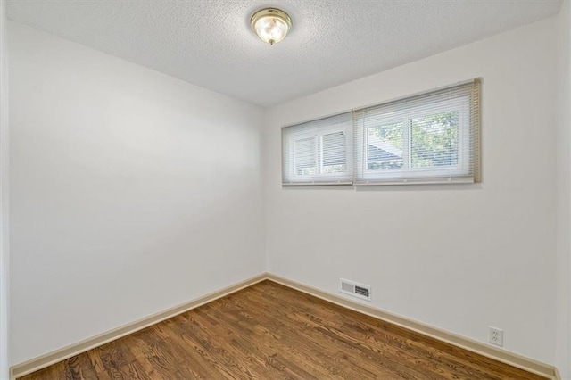 10720 Sycamore Ter, Kansas City, MO 64134 - unfurnished room featuring baseboards, a textured ceiling, and dark wood-style floors