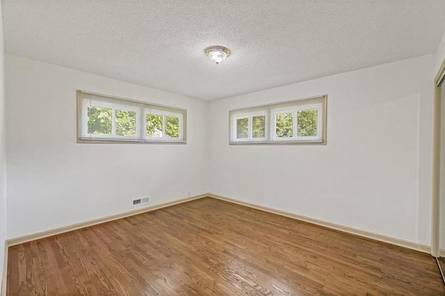10720 Sycamore Ter, Kansas City, MO 64134 - unfurnished room featuring wood finished floors, a textured ceiling, and baseboards