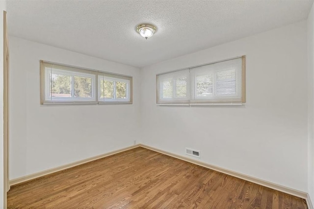 10720 Sycamore Ter, Kansas City, MO 64134 - unfurnished room with wood finished floors, a textured ceiling, and baseboards