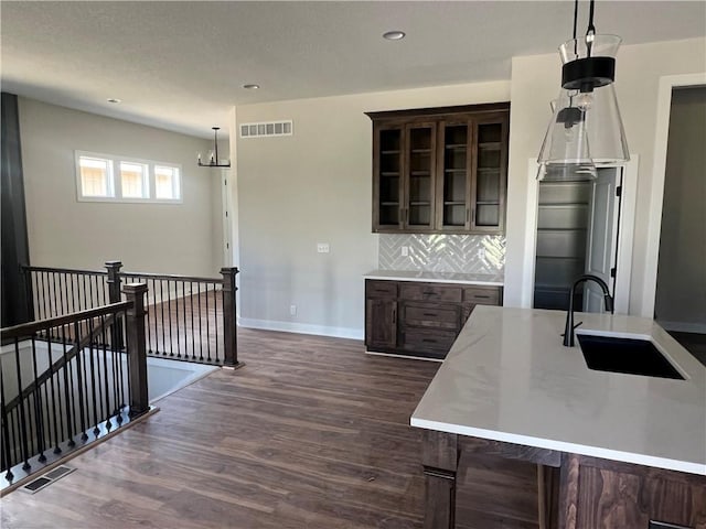 1516 SW Arborpark Ter, Lees Summit, MO 64082 - kitchen with a sink, dark brown cabinets, dark wood-type flooring, light countertops, and decorative backsplash