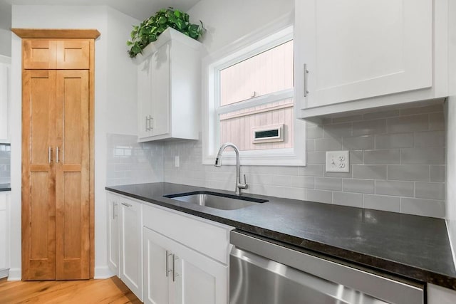 17756 Shady Bend Rd, Gardner, KS 66030 - kitchen featuring stainless steel dishwasher, a sink, tasteful backsplash, and white cabinetry