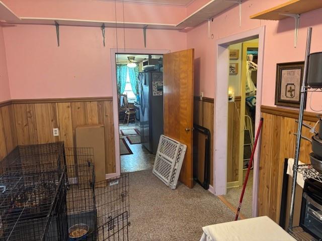 1119 Mound St, Atchison, KS 66002 - miscellaneous room with wainscoting, wooden walls, ceiling fan, and carpet floors