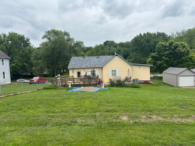 1119 Mound St, Atchison, KS 66002 - rear view of house with a lawn, a garage, an outdoor structure, and a wooden deck