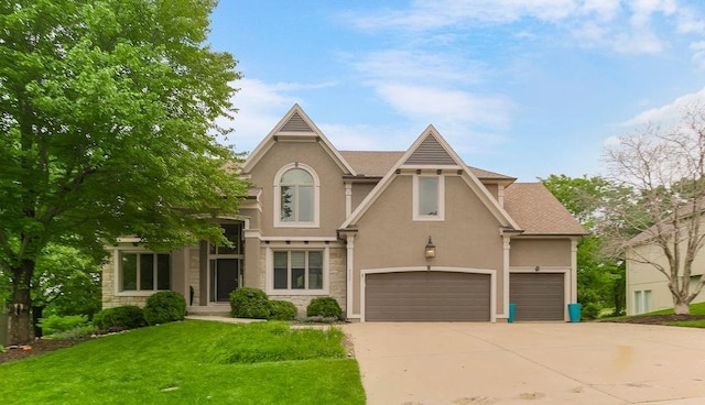 9233 Redbud Ln, Lenexa, KS 66220 - view of front facade featuring stucco siding, a front lawn, concrete driveway, and stone siding