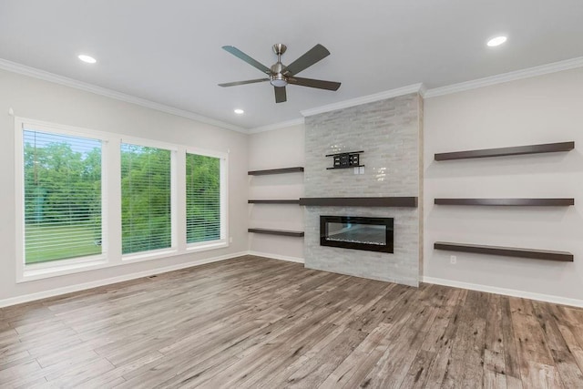 7515 Locust Dr, Kansas City, MO 64152 - unfurnished living room featuring wood finished floors, a ceiling fan, healthy amount of natural light, a large fireplace, and ornamental molding