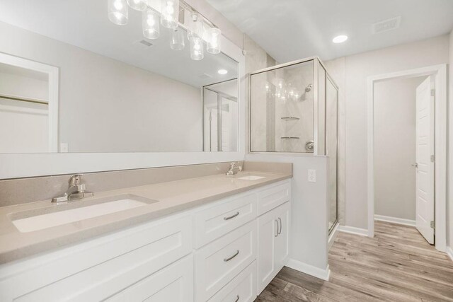 7515 Locust Dr, Kansas City, MO 64152 - full bathroom with a stall shower, double vanity, wood finished floors, and baseboards