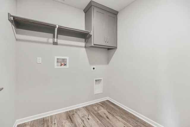 7515 Locust Dr, Kansas City, MO 64152 - laundry room with hookup for a washing machine, hookup for an electric dryer, wood finished floors, baseboards, and cabinet space